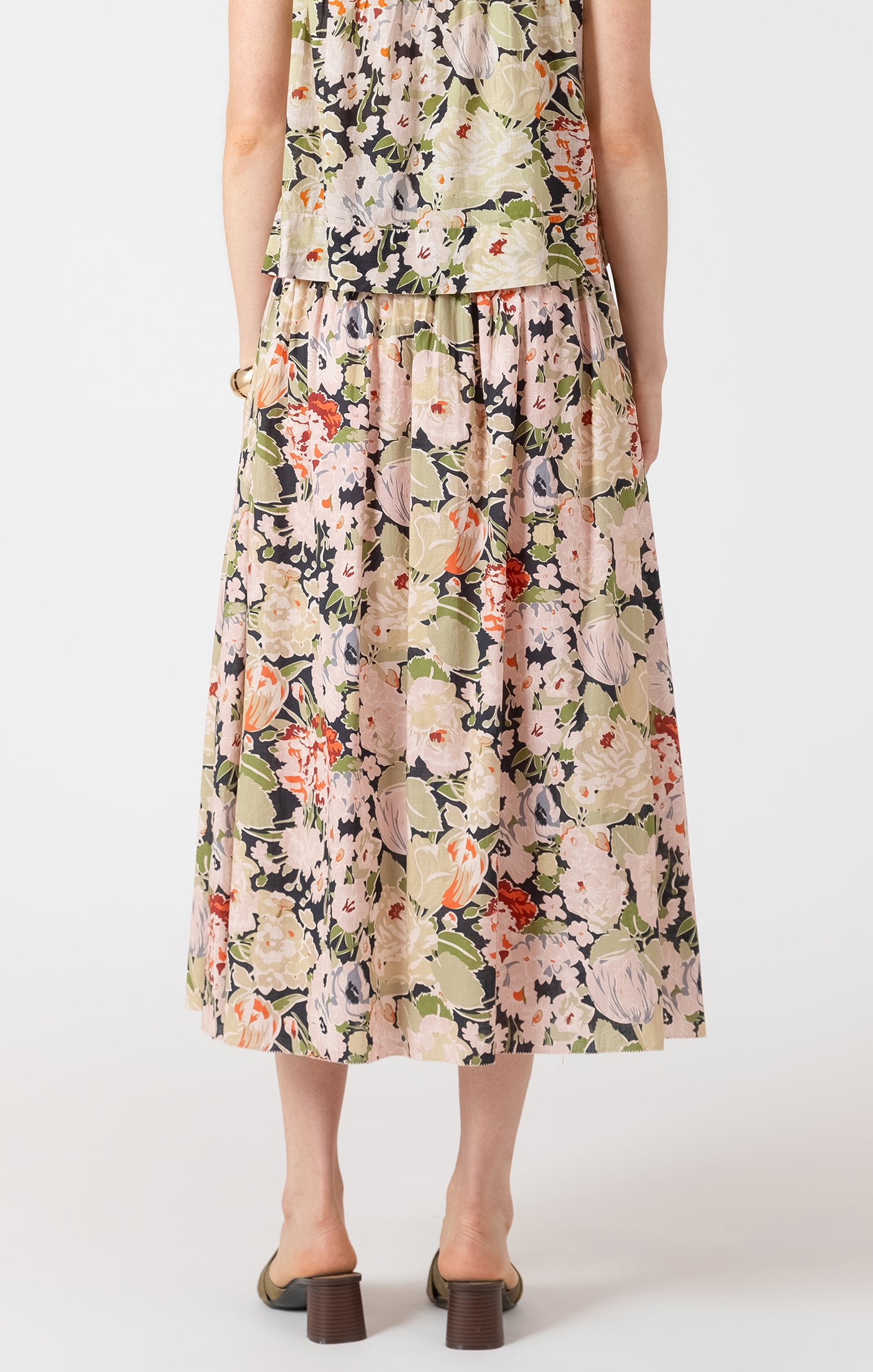 Person wearing a floral dress on a white background