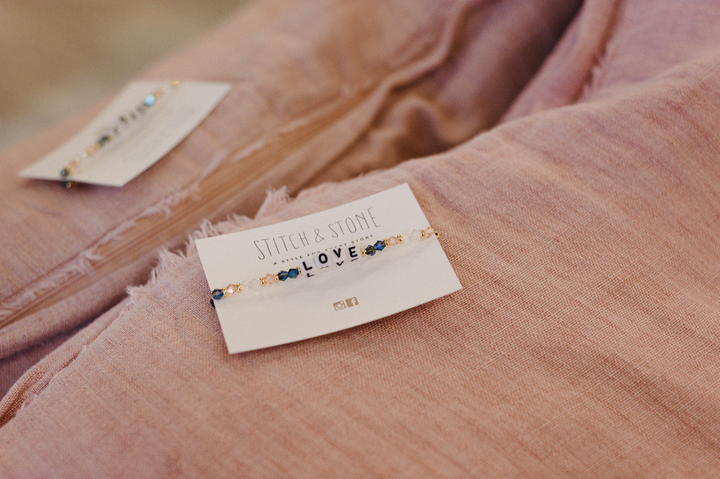 Bracelets on a card with 'Stitch & Stone' branding on pink fabric