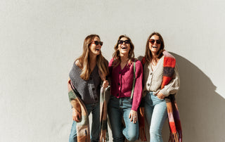 three women in matching cardigans laughing