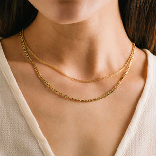 women wearing a gold layered necklace.