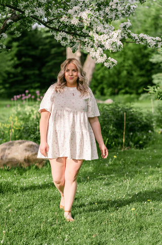 Women wearing a floral tiered ruffle dress under a cherry blossom tree