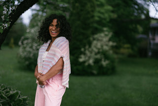 women pink pants and a rainbow cardigan on her shoulders