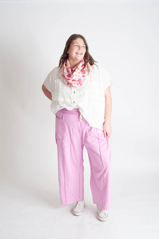 women wearing a white blouse and pink pants on a white background.