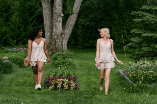 Women wearing matching ruffle sets walking in a garden.