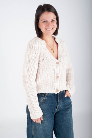 Women wearing a knit cardigan against a white background