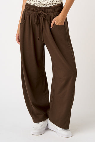 Brown wide-leg pants worn by a person on a white background