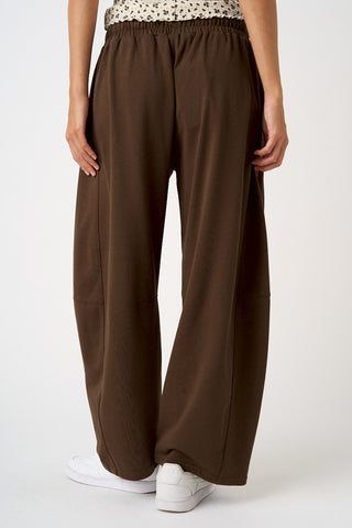 Brown wide-leg pants worn by a person on a white background