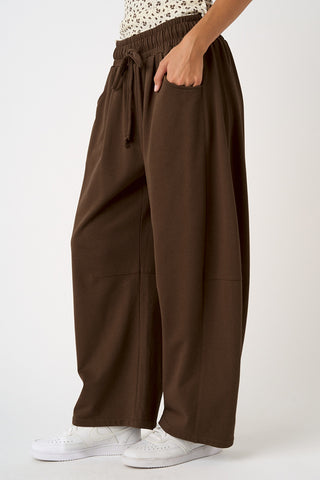 Brown wide-leg pants worn by a person on a white background