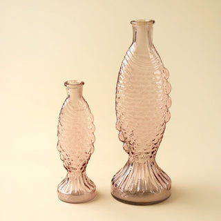 Two pink fish glass vases with textured design on a beige background