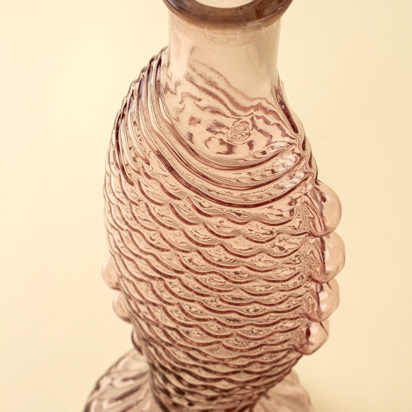 Decorative vase with wavy fish pattern on a beige background