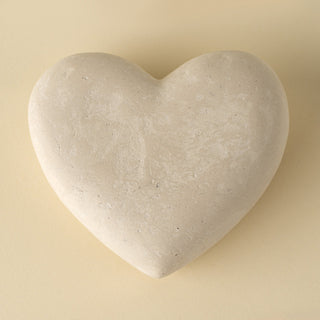 Heart-shaped stone on a beige background