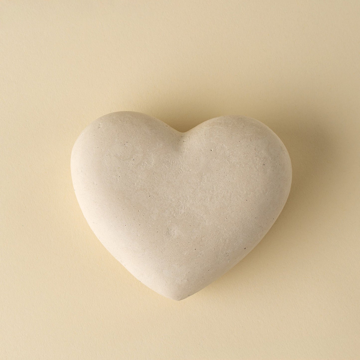 Heart-shaped stone on a beige background