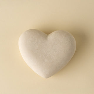 Heart-shaped stone on a beige background
