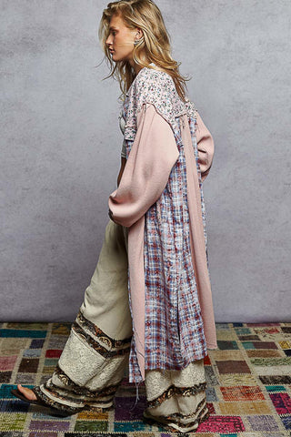 Women wearing a plaid long jacket against a neutral background.