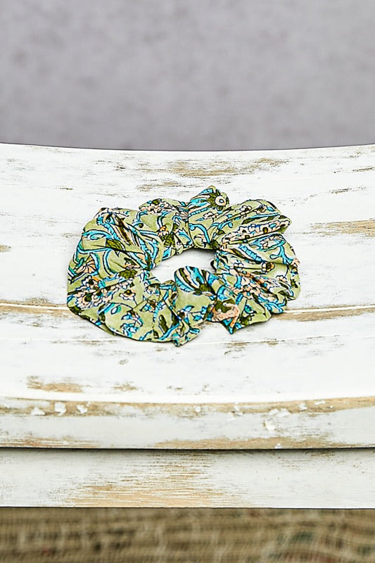 Green and blue patterned scrunchie on a wooden surface