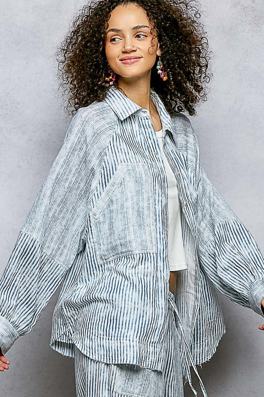 Woman wearing a striped outfit against a gray background