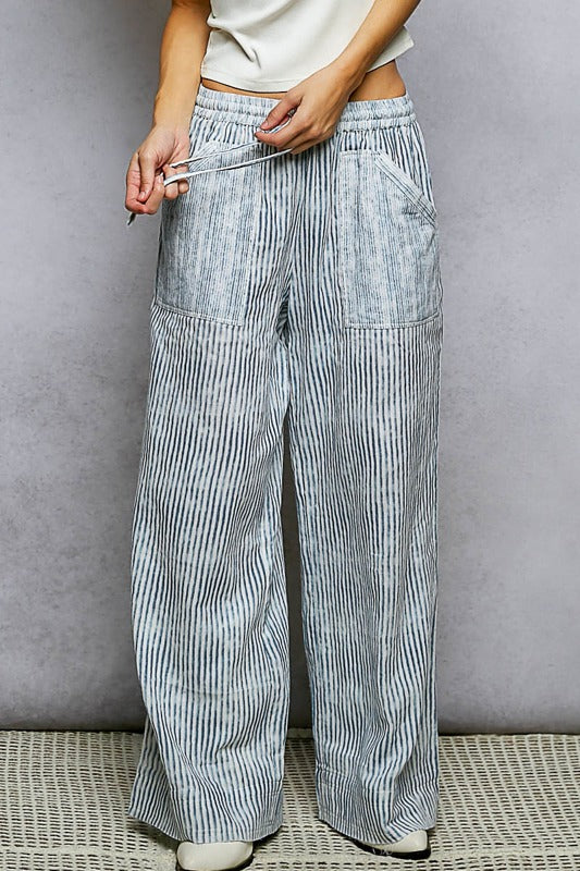 Person wearing light blue striped pants against a gray background