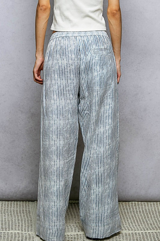 Person wearing light blue striped pants against a gray background