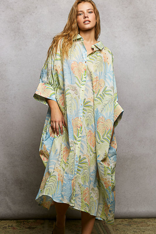 Woman wearing a long, floral-patterned dress against a gray background