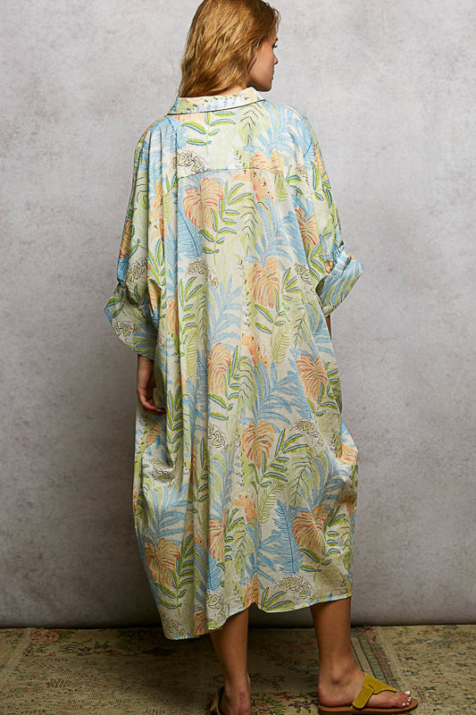 Woman wearing a colorful floral dress against a plain background