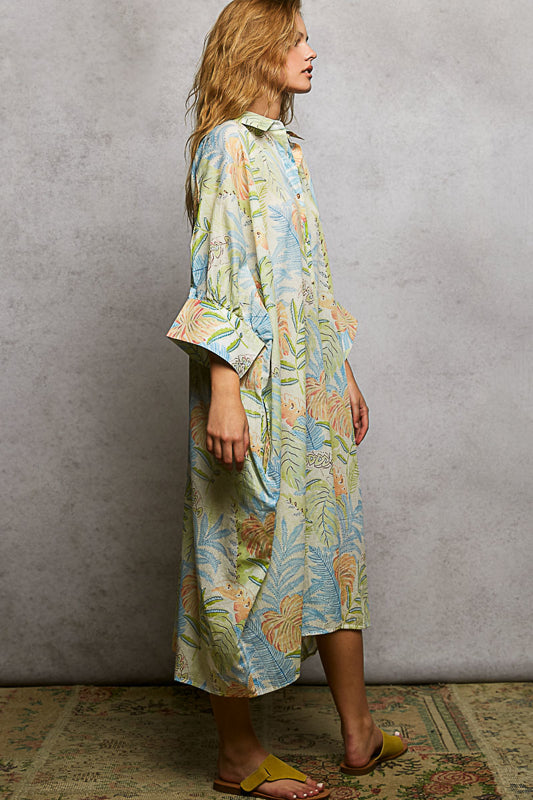 Woman wearing a colorful floral dress against a plain background