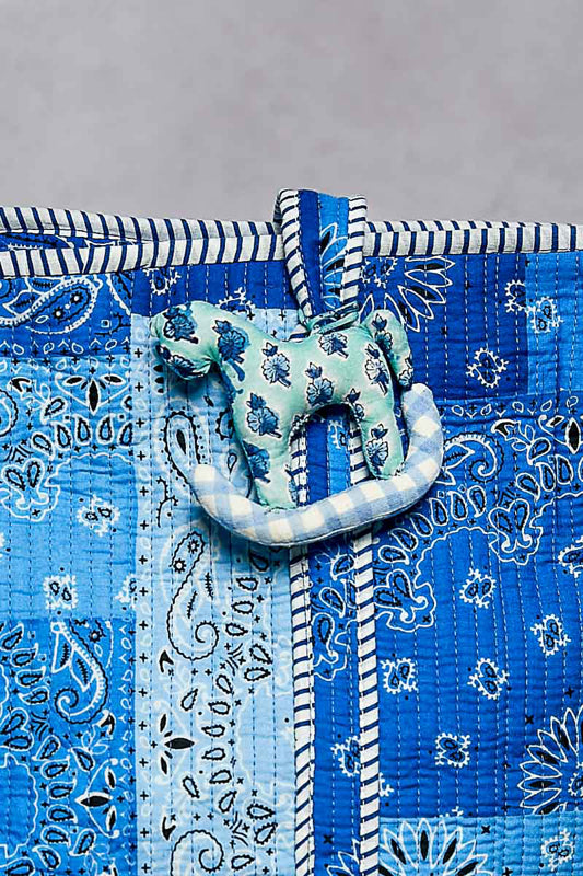 Blue bandana with a decorative green and white knot on a gray background