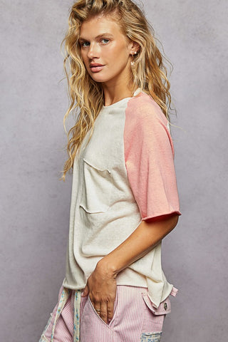 Woman wearing a light gray and pink outfit against a gray background