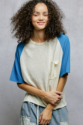 Woman wearing a blue and beige t-shirt with a gray background
