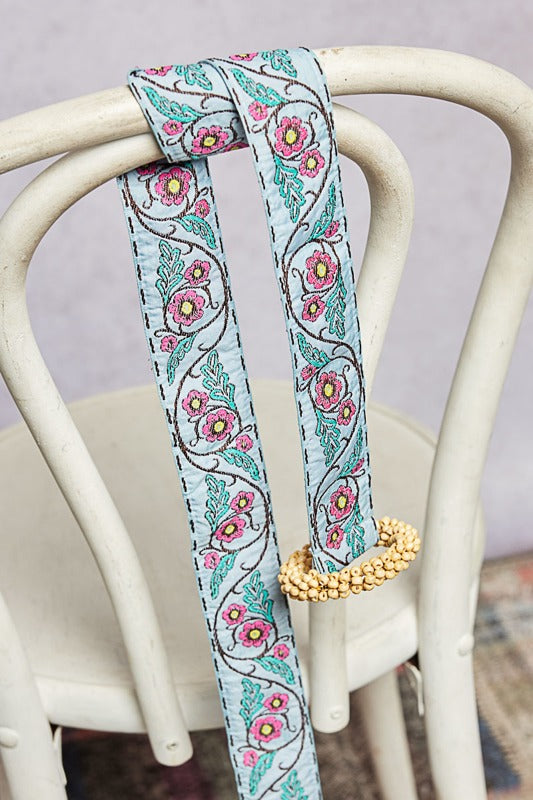 Floral patterned belt with a beaded end on a chair
