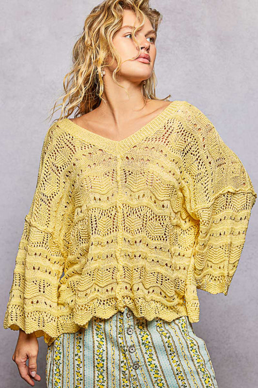 Woman wearing a yellow lace top against a gray background
