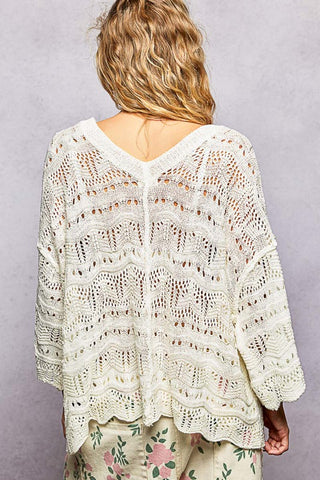 Person wearing a white lace top against a gray background