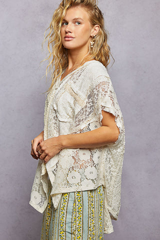Woman wearing a floral blouse and skirt against a gray background