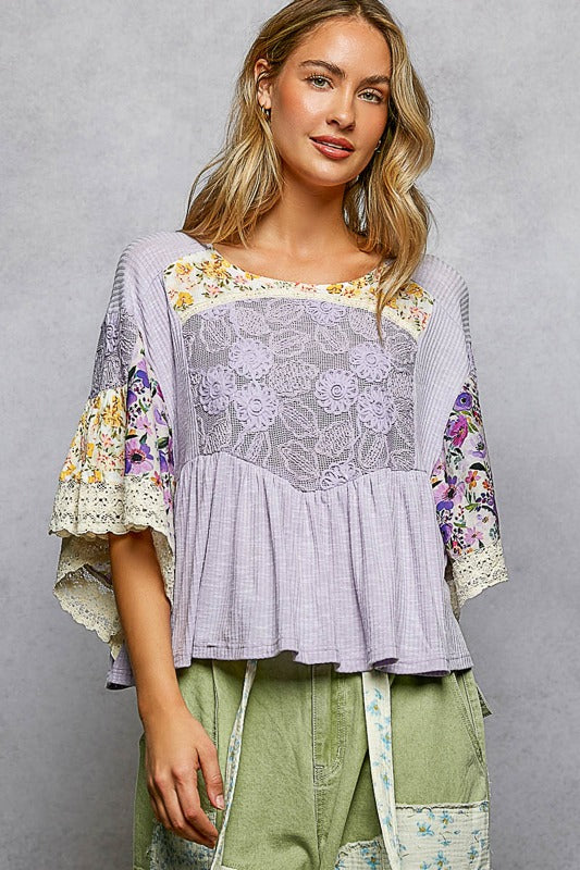 Woman wearing a purple floral blouse with a gray background