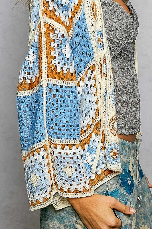 Person wearing a patterned scarf and skirt against a gray background