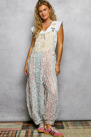 Woman wearing a patterned overalls against a gray background