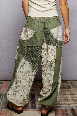 Person wearing patchwork pants with a neutral background