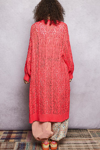 A Women wearing a colour knit cardigan on a neutral background.