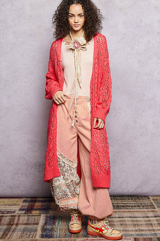 A Women wearing a colour knit cardigan on a neutral background.
