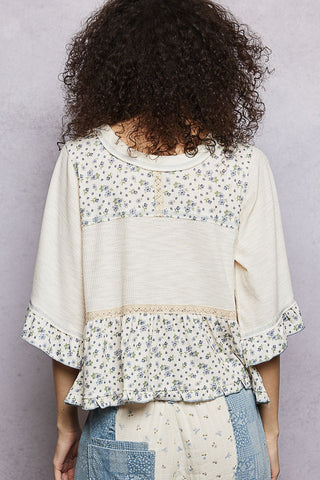 Person wearing a floral blouse with a plain background