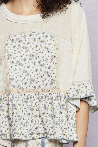Floral patterned top with ruffled sleeves and hem on a plain background