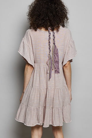 Woman wearing a beige dress with a plain background