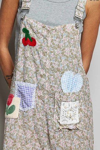 Floral dress with patchwork design and cherry applique on a plain background