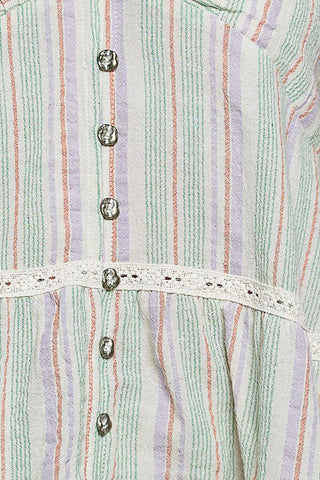 Close-up of a striped garment with buttons and lace trim.