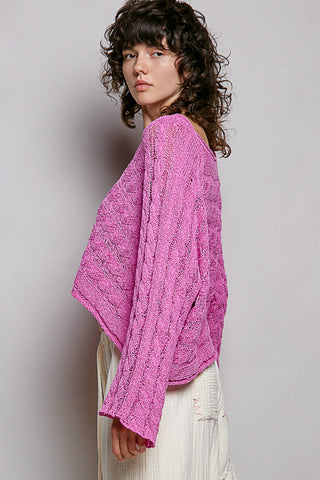 women wearing a bright pink knit sweater on a grey background