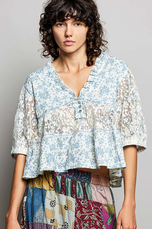 Woman wearing a floral blouse with a colorful skirt against a gray background