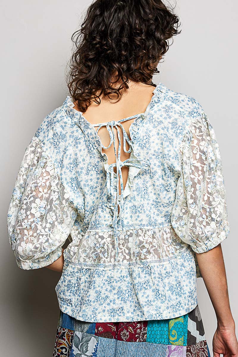 Person wearing a floral blouse with a plain background