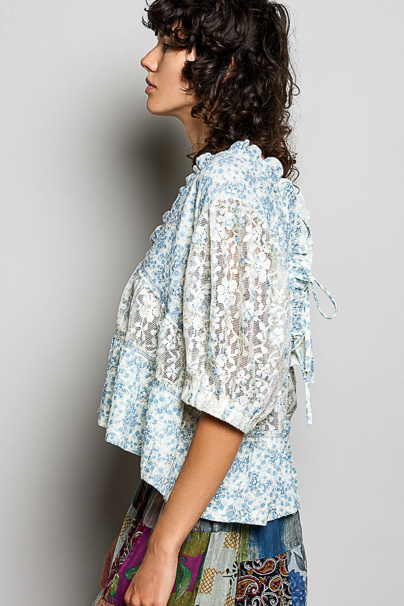 Woman wearing a light blue floral blouse with a blurred background