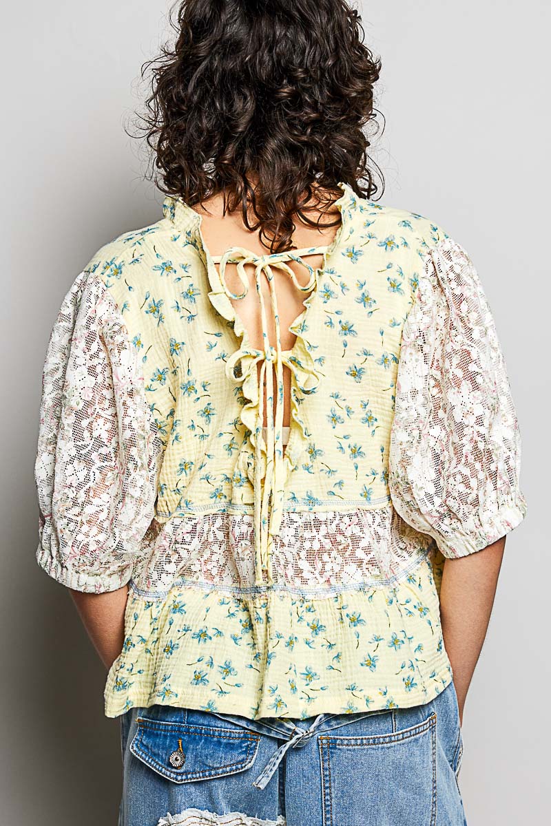 Women wearing a yellow floral and lace design top. 
