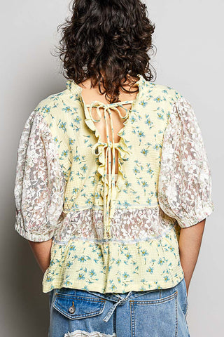 Women wearing a yellow floral and lace design top. 