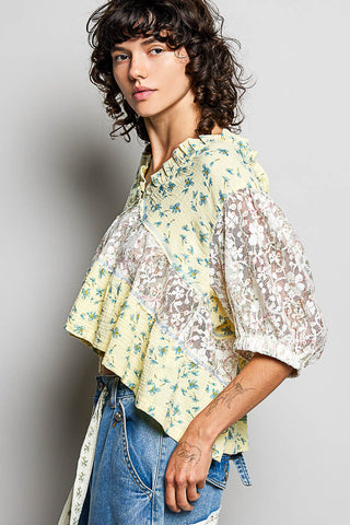 Women wearing a yellow floral and lace design top. 
